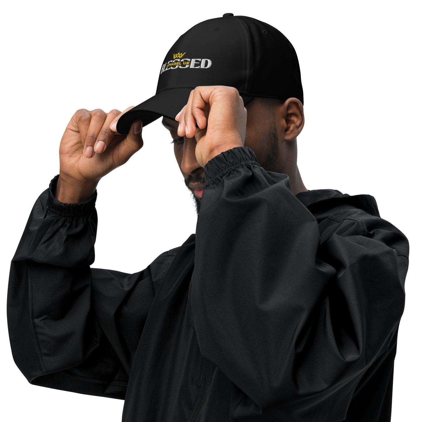Image of a person holding the peak of a baseball cap with blessed apparel logo in yellow and white.