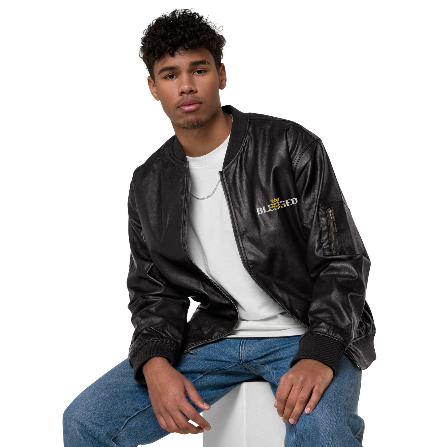 Image of a seated person wearing a black jacket with blessed apparel logo in yellow and white.
