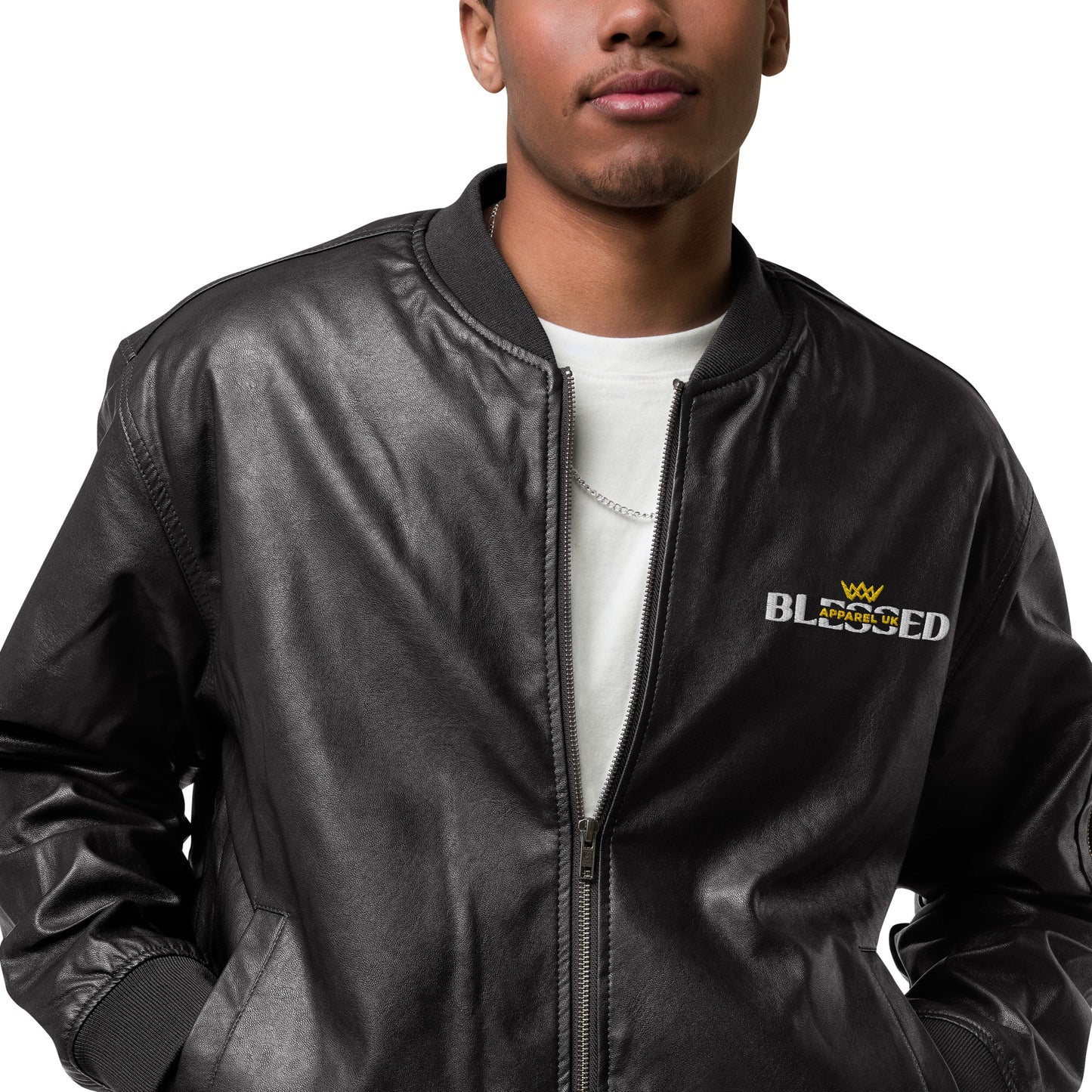 Close up image of a smiling person wearing a black jacket , half zipped with blessed apparel logo in yellow and white.
