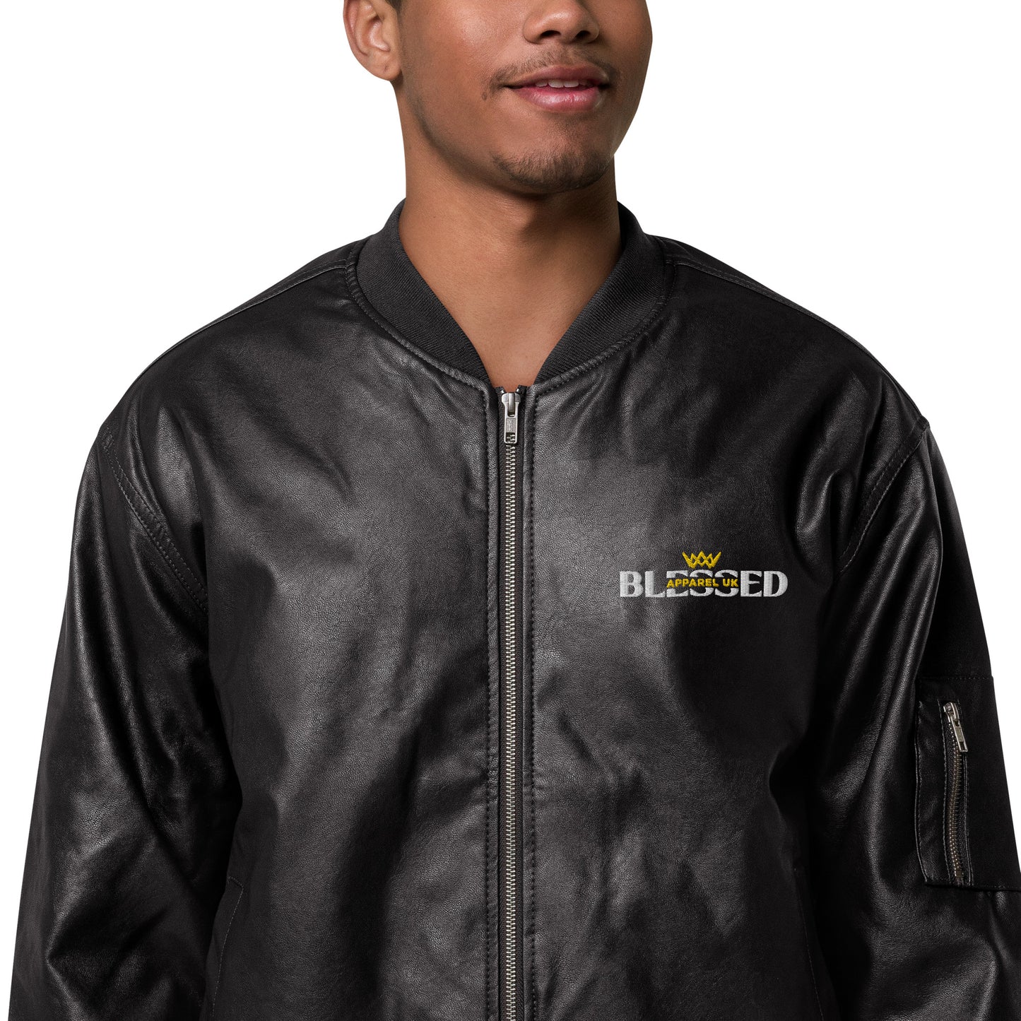 Close up image of a smiling person wearing a black jacket with blessed apparel logo in yellow and white.