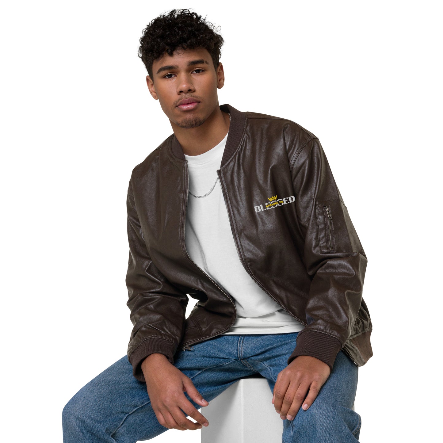 Image of a smiling person wearing a brown jacket with blessed apparel logo in yellow and white.