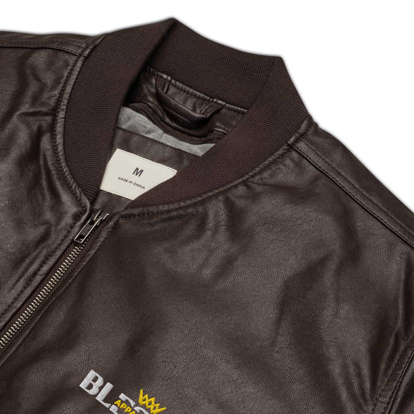 Close up Image of a brown jacket with blessed apparel logo in yellow and white.