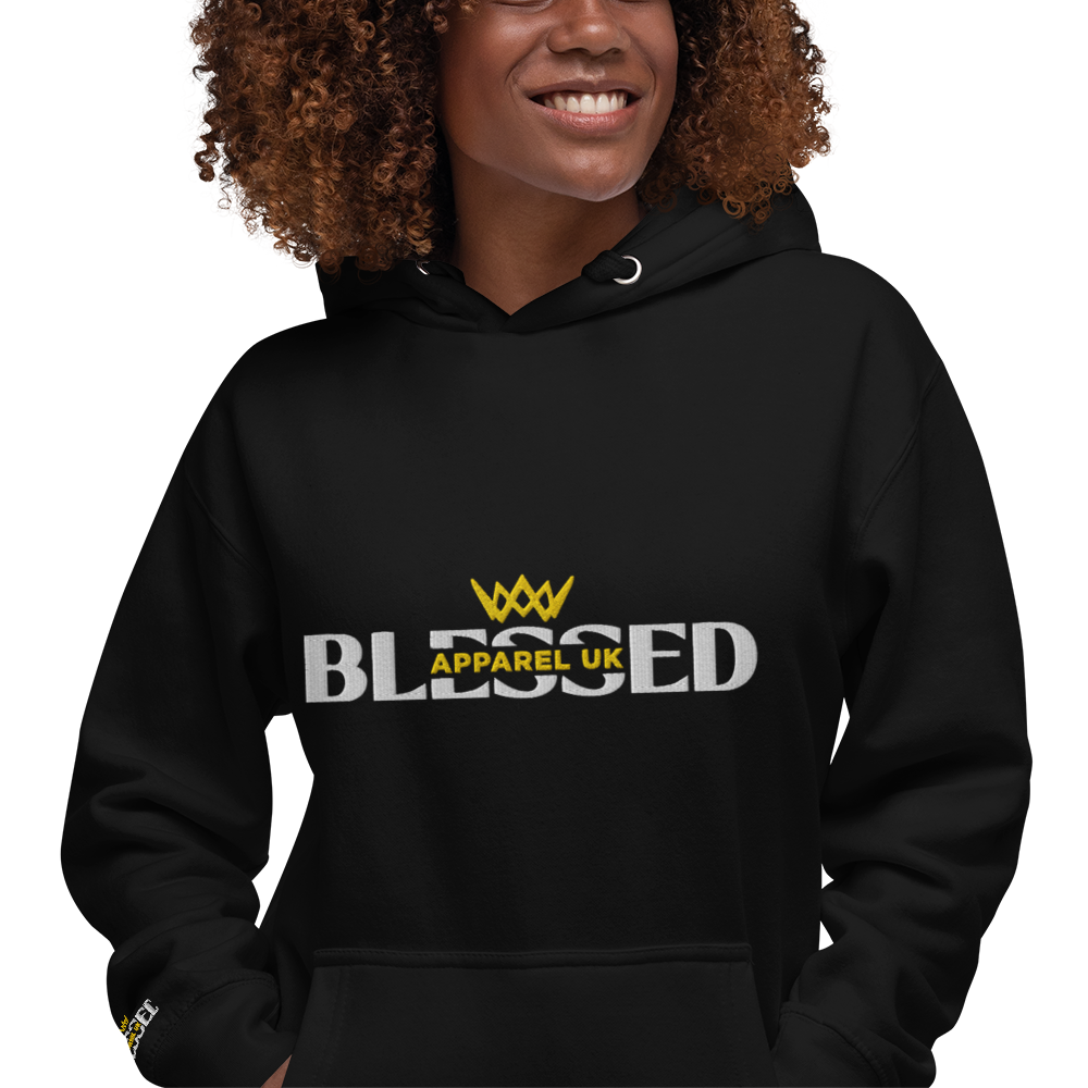 Close up image of a smiling person wearing a black hoodie with blessed apparel logo in yellow and white.