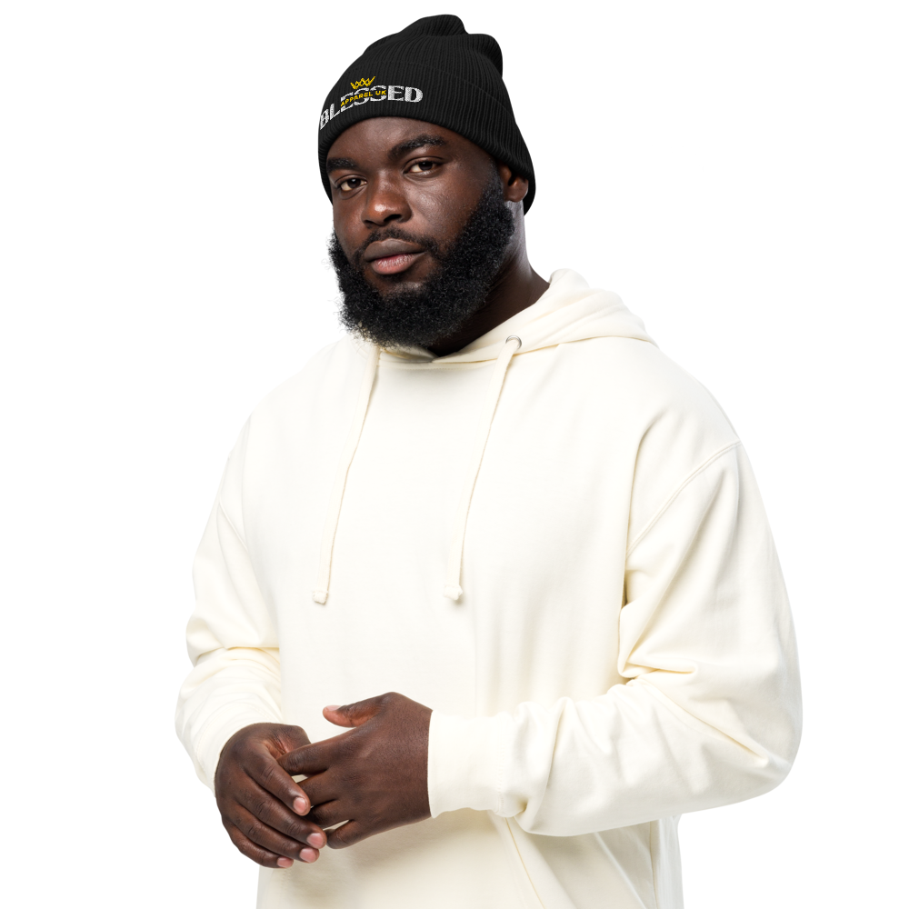 Image of a person wearing a beenie hat with blessed apparel logo in yellow and white.