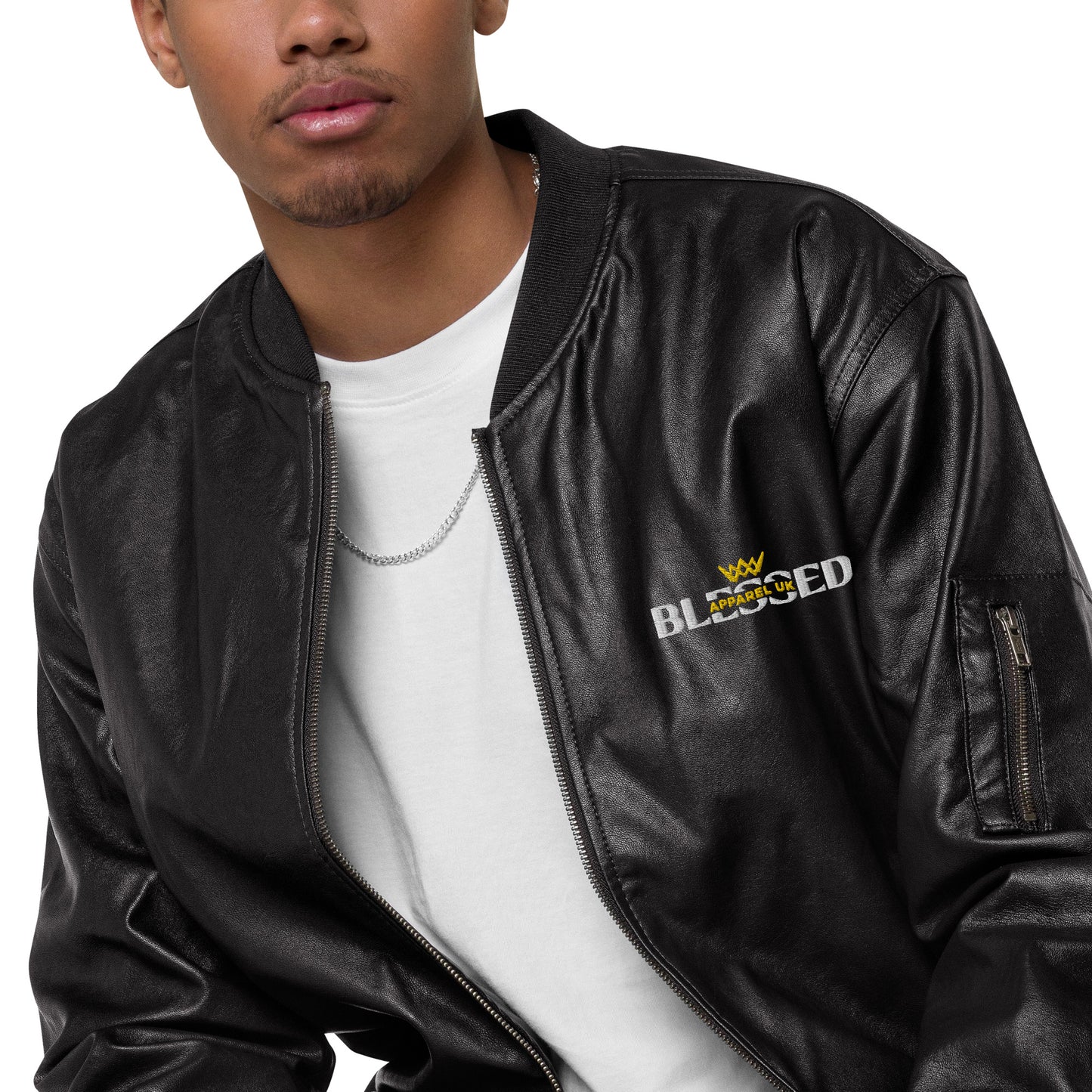 Close up image of a person wearing an open black jacket with blessed apparel logo in yellow and white.