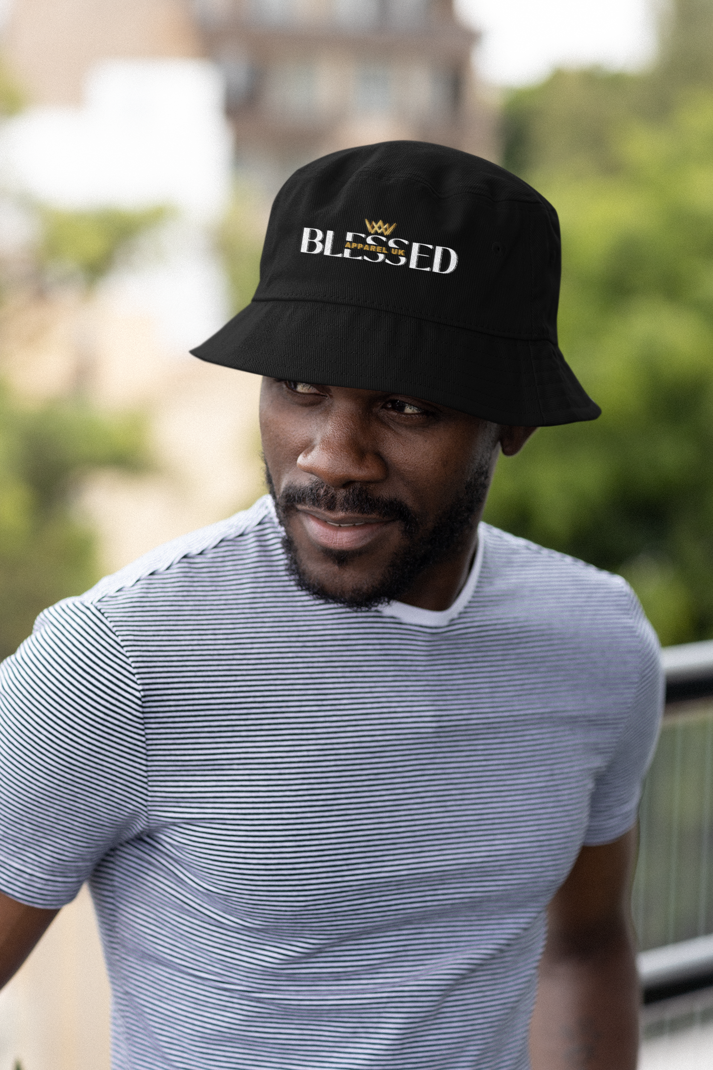 Image of a person wearing a bucket hat with blessed apparel logo in yellow and white.