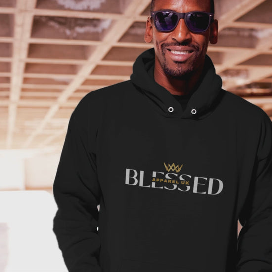 Video of a person walking, wearing a black hoodie with blessed apparel logo in yellow and white.